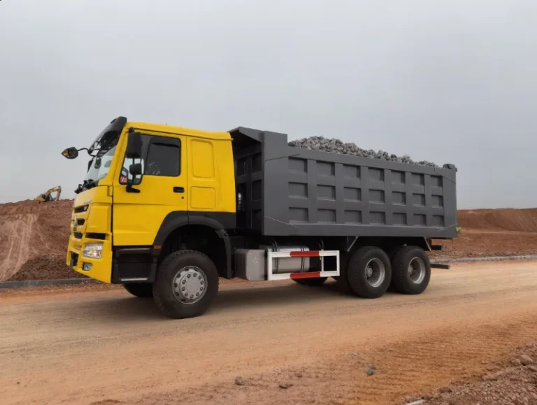 HOWO 371 dump truck with a loaded tipping body parked on a gravel haul road