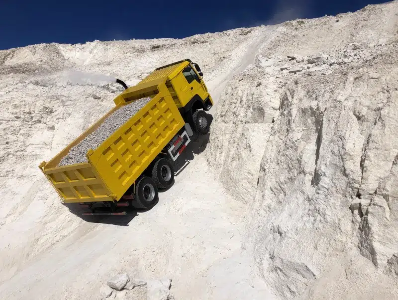 HOWO 371 dump truck climbing a quarry ramp with a full load of crushed rock