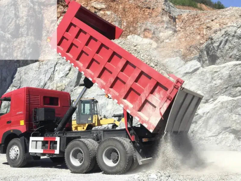 Camión volquete HOWO A7 8×4 descargando áridos en una cantera.