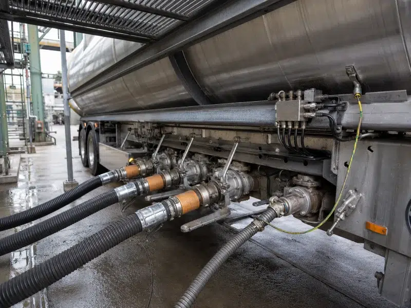 Bottom loading adapters and vapour recovery line connected to a tanker at a loading rack.